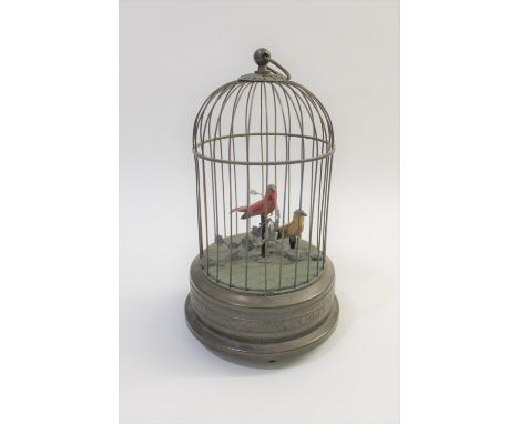 A 20thc bird automaton, with a clockwork mechanism operating two birds which move and sing. The birds in a metal cage with ca