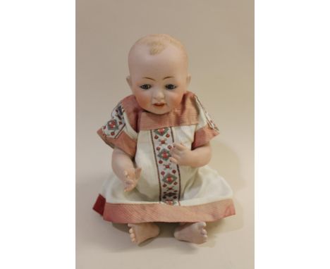 The small doll with fixed blue eyes and open mouth, with painted hair, porcelain body and porcelain bent limbs. Impressed mar