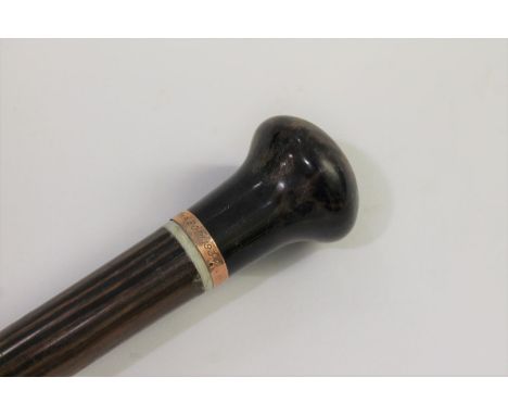 A walking cane with a tortoiseshell knob, mounted with a 9ct gold collar which is inscribed 'W H Sawtell, Mar 20th 1934', whi