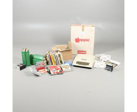 A vintage Apple II computer in its original box, also with controllers and disc drives, various games, instruction manuals, v