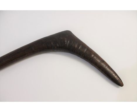 An aboriginal leangle throwing club, with a carved grip and stepped conical terminal.  80cms long from tip to tip, main shaft