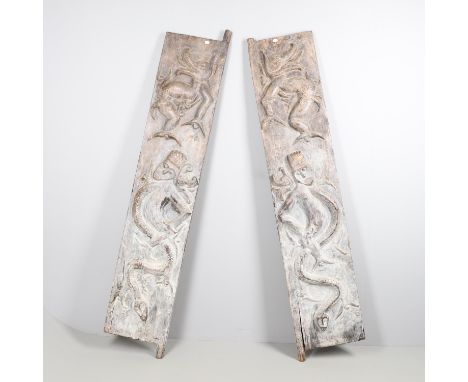 A large pair of wooden doors, each carved with figures entwined with snakes, and other animals. Approx 203cms and 197cms high