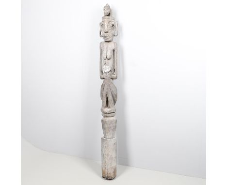 A large carved figure/column, with a figure holding a Chicken and with a further animal on its head. The reverse carved with 