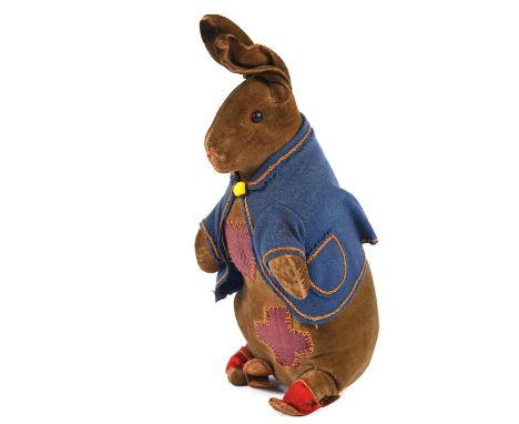 An early 20thc Steiff soft toy of Peter Rabbit, with a blue felt jacket and pair of red slippers. Missing its button, 26.5cms