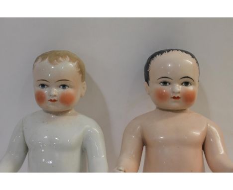 Two large all porcelain dolls or 'Frozen Charlottes', both with painted hair and faces and with arms outstretched in front of