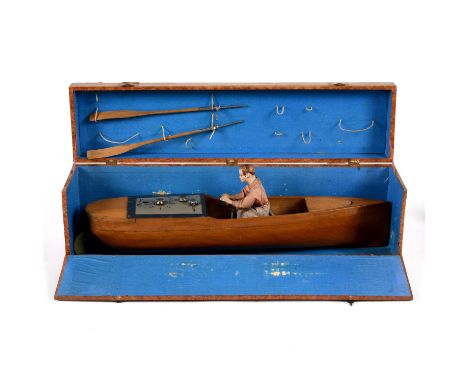 A rare wooden hulled toy boat, with a clockwork mechanism and adjustable dials including distance and direction. With a seate