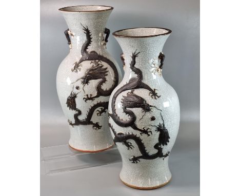 Mirror matched pair of Chinese porcelain baluster vases, depicting two writhing brown coloured five claw Dragons in relief co