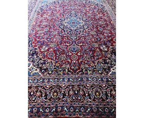 Red and blue ground Persian Kashan carpet with traditional designs, central medallion, flanked by repeating borders.  384x290