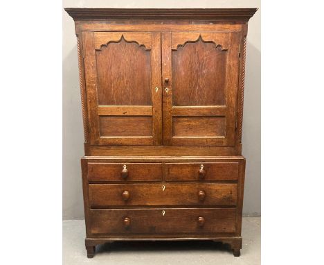 Late 18th/early 19th century Welsh oak two stage press cupboard, the moulded cornice above two blind panel ogee pointed field