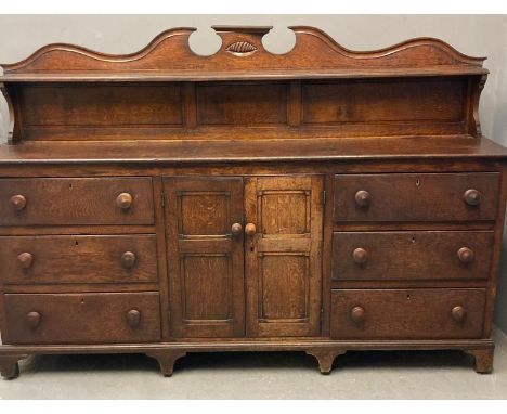 Early 19th century Welsh oak sideboard, the shaped gallery back above a moulded top with an arrangement of six drawers, two c
