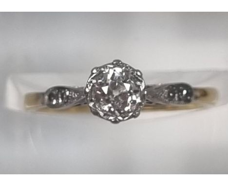 Yellow metal, probably 18ct gold diamond solitaire ring flanked by two further tiny diamonds set to the shank in crown settin
