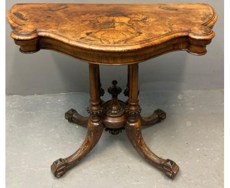 Victorian walnut fold over card table, the moulded and shaped top with hinged lid, above carved quatrefoil base and ceramic c