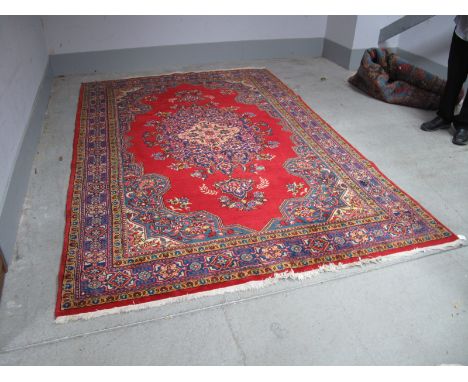 Middle Eastern Sarough Style Wool Tasseled Carpet, with shaped central motif, geometric and floral border on turkey red groun