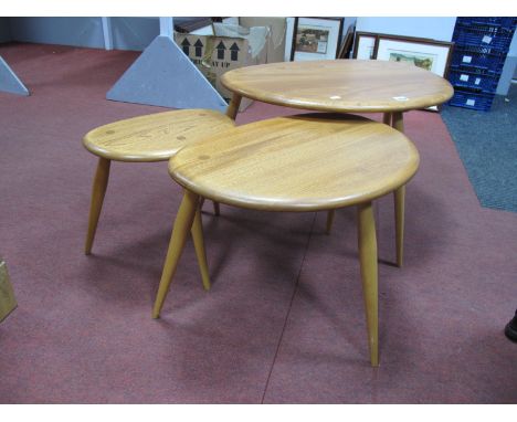 Ercol; A Nest of Three Light Elm Pebble Top Coffee Table, each on three spindle legs, the tallest 40cm, and bearing crown lab