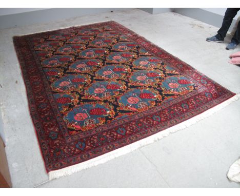 Middle Eastern Senneh Style Wool Tassled Carpet, with twenty four central motifs within a geometric boarder on deep blue and 