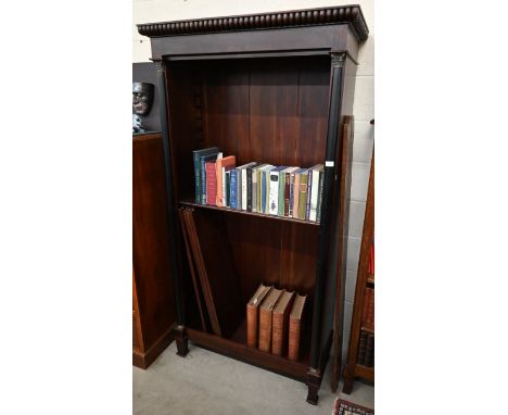 A large stained hardwood open bookcase with five shelves between ebonised and brass mounted classical columns, lacking many s