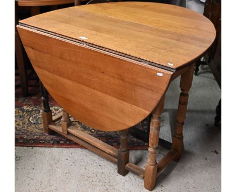 An early 20th century oak drop-leaf dining table on turned gate-leg action base&nbsp;