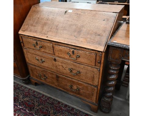 A George III oak fall-front bureau with fitted interior over two short and two long drawers with brass handles, raised on sha