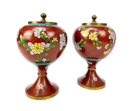 PAIR OF 20TH CENTURY CHINESE CLOISONNÉ ENAMEL LIDDED POTS, of ovoid shaped with flaring stems, decorated with flowers on a re