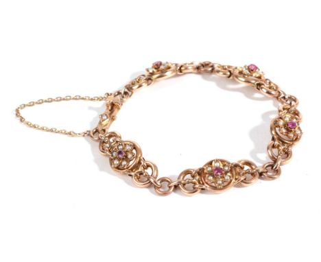 An Early 20th Century Ruby and Seed Pearl Bracelet, round cut rubies within borders of seed pearls, to create floral motifs w