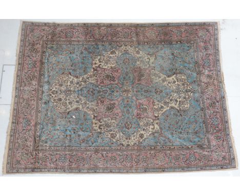 Kirman Carpet South East Iran, 1950 The ivory field centred by a sky blue and coral pink medallion framed by sky blue spandre