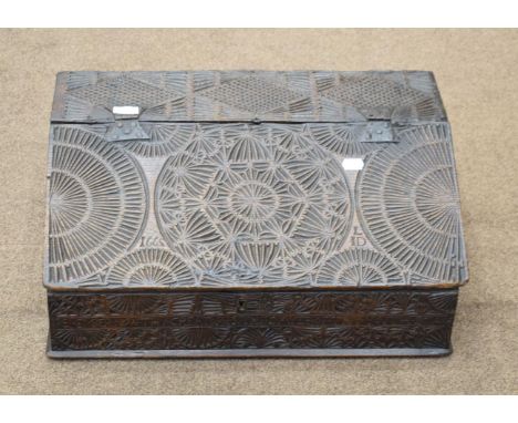 A 17th Century Carved Oak Bible Box, with geometric decoration, bearing the date 1665 and initialled LID, the hinged slope en