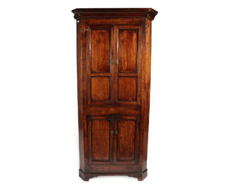 A Mid 18th Century Joined Oak Free-Standing Corner Cupboard, the moulded cornice above cupboard doors with four moulded panel