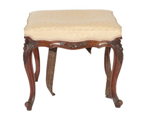 ~ A Victorian Carved Walnut Dressing Stool, late 19th century, recovered in cream and blue floral fabric, the serpentine carv