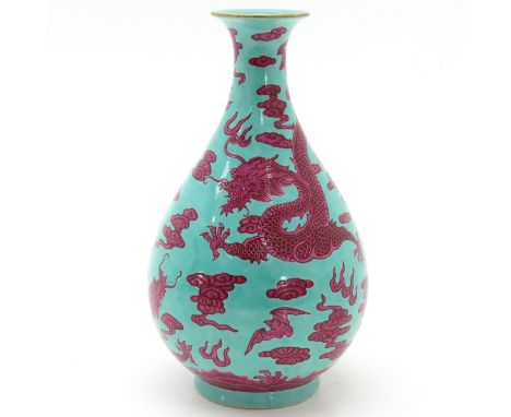 Light green ground with five clawed dragons and clouds in ruby red enamels, marked with four Chinese characters, 23 cm. tall.