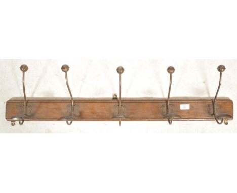 A vintage Industrial 20th century wall mounted coat stand. The oak plinth base with fabulous oversized cast metal hanging hoo