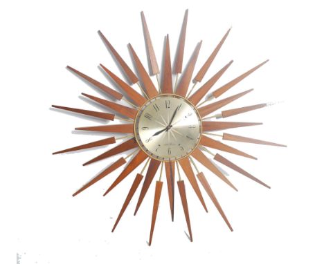 A vintage mid century teak wood sunburst wall clock by Seth Thomas. The teak rays with gilded circular sun face centre. Measu