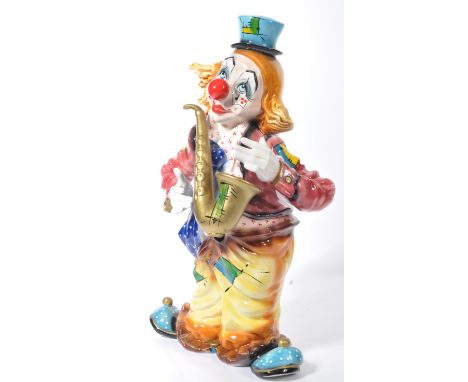 A fantastic 20th century ceramic floor standing clown, finished with an enamel glaze, the clown having a multi coloured outfi