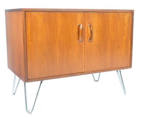 A vintage 20th century retro teak wood G-Plan sideboard dresser being raised on hairpin metal legs supporting a single cupboa