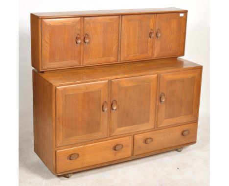 A 20th century light elm and beech wood twin section sideboard dresser by Ercol. Raised on castors with lower drawers and cup