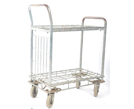 A vintage retro industrial shops tote / shop assistants metal tubular trolley. Having two wire mesh tiers, handle to the fron