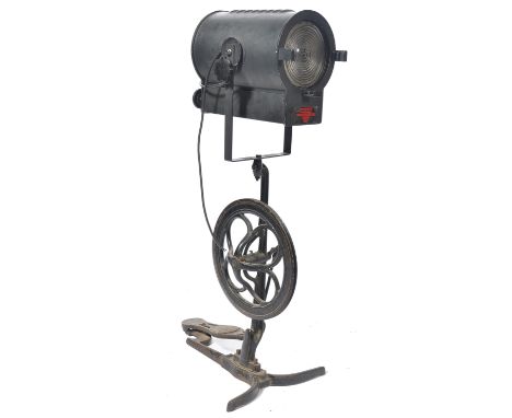 A mid century vintage film - theatre spot light by Malham. Model SE23. The vintage lamp being raised onto an upcycled pedal m