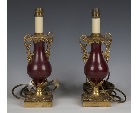 A pair of early 20th century gilt metal and claret lacquered table lamps, height 33cm.Buyer’s Premium 29.4% (including VAT @ 