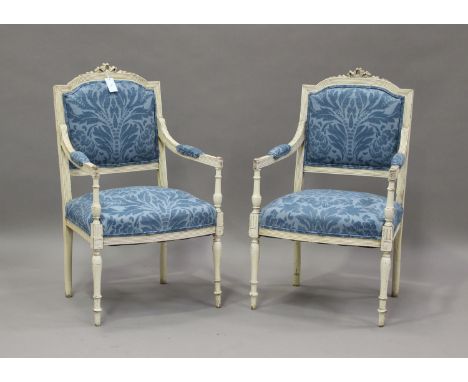 A pair of late 19th/early 20th century French white painted fauteuil armchairs, upholstered in blue patterned fabric, on turn