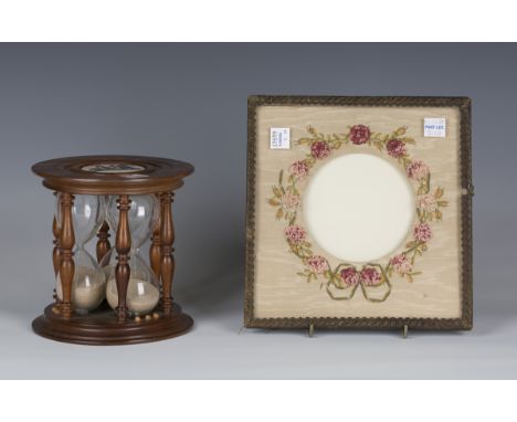 A 20th century mahogany framed triple glass egg timer, the two ends inset with ceramic plaques, height 13.5cm, diameter 13.8c