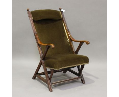A late Victorian Aesthetic Movement walnut framed library chair, upholstered in green velour, on 'X'-frame supports, height 9