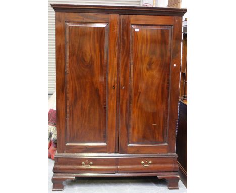 A George V mahogany wardrobe, fitted with a pair of panel doors above two drawers, on bracket feet, height 195cm, width 136cm