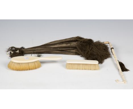 A 19th century ivory handled folding parasol with silk canopy, and two Victorian ivory hand brushes.Buyer’s Premium 29.4% (in