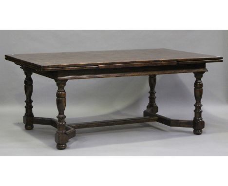 A 20th century oak draw-leaf dining table with parquetry top, on turned baluster legs, height 77cm, length 186cm, depth 114cm