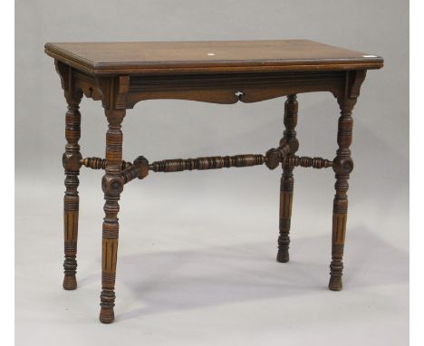 A late Victorian walnut fold-over card table by Gillows, raised on ring turned legs, height 76cm, width 92cm, depth 46cm.Buye