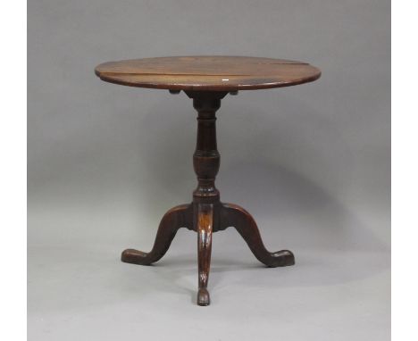 An 18th century oak tip-top circular wine table, on a turned column and tripod cabriole legs, height 70cm, depth 72cm.Buyer’s