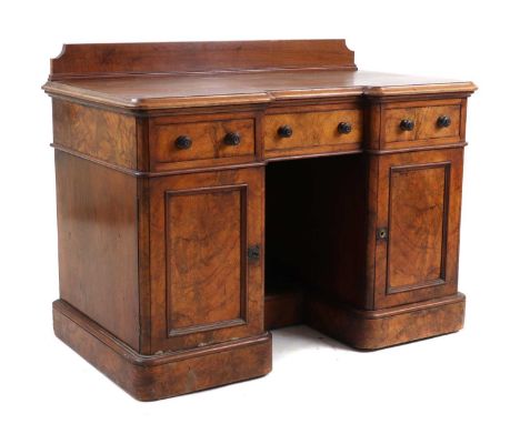 A Victorian walnut breakfront pedestal desk,with a moulded top, to an inverted breakfront, with two frieze drawers, over two 