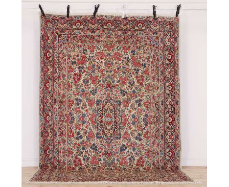 A Persian wool carpet, mid-late 20th century, Kirman, woven with dense flowers and foliage to a pale ground,291 x 195cmProven