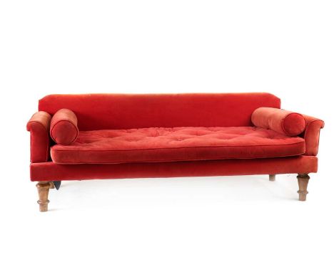 A beech drop-arm sofa, late 19th/ early 20th century, with red velvet upholstery, a buttoned seat cushions and a pair of loos