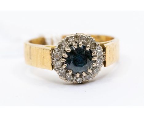 A sapphire and diamond and 18ct gold ring, comprising claw set round cut sapphire approx. 5mm, set within a claw set border o