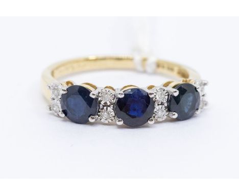 A sapphire and diamond 9ct gold ring, comprising three round cut blue sapphire, claw set in a row, with alternate double diam